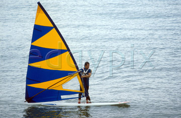 Comp image : boat0209 : Windsurfer with blue and yellow sail on calm water