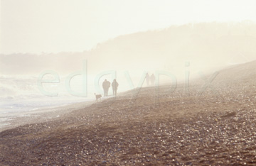 Comp image : ea00320 : People in silhouette walking on the shingle at Dunwich, Suffolk, on the east coast of England