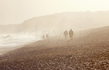 Comp image : ea00323 : People in silhouette walking on the shingle at Dunwich, Suffolk, on the east coast of England