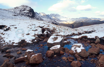 Comp image : ld02611 : Snow-covered Crinkle Crags, Great Langdale, in the English Lake District, under a blue sky, with rocks in a stream in the foreground