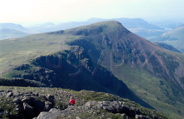 Comp image : ld03902 : A walker in red rests in the summer sun on High Stile (above Buttermere) in the English Lake District. Red Pike in the background.