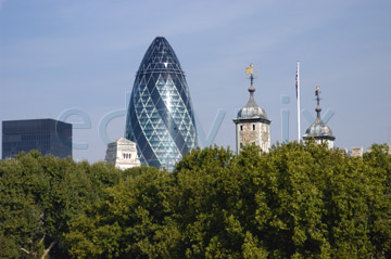 Comp image : lond010018 : The old and the new: Sir Norman Foster's 'gherkin' and the historic Tower of London peer above the trees on the north bank of the River Thames in London, England