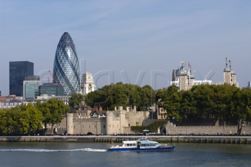 Comp image : lond010024 : Old and new: Sir Norman Foster's 'gherkin' and the historic Tower of London seen from the south bank of the River Thames in London, England, with a boat in the mid distance