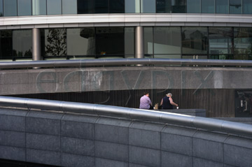 Comp image : lond010034 : Dramatic shapes of buildings in the 'More London' development on the south bank of the River Thames in London, England. Two people have a picnic.