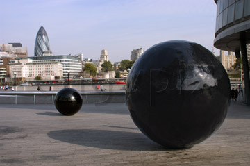 Comp image : lond010042 : The 'black ball' sculptures outside London's City Hall; Sir Norman Foster's 'gherkin' on the skyline beyond