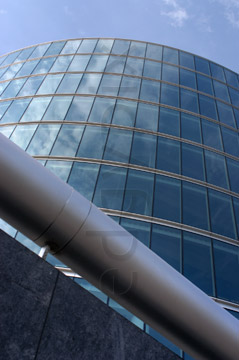 Comp image : lond010051 : Dramatic view looking up at a curved glass London building reflecting the blue sky