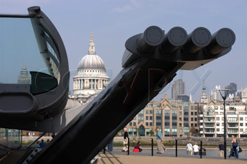 Comp image : lond010096 : Dramatic end-on view of the Millennium Bridge over the River Thames in London, England, with St. Pauls Cathedral in sunshine on the other side of the river