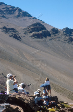 Comp image : mgun0720 : A resting group of trekkers is dwarfed by the bulk of Jebel Rhat, a mountain in the High Atlas mountains of Morocco; a massive field of scree in the mid distance