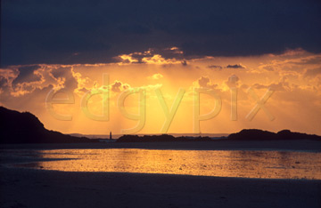 Comp image : sky0104 : Dramatic orange sunset and its reflection under a heavy dark cloud at the sea shore