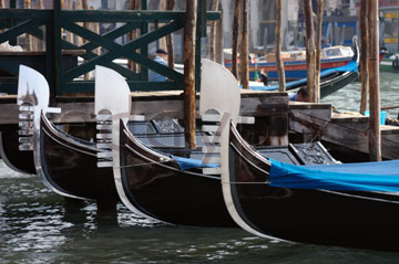 Comp image : ven021296 : Bow 'flags' (ferri) of gondolas moored on the Grand Canal in Venice, Italy. The six projections of the ferro symbolise the six districts (sestieri) of the city.