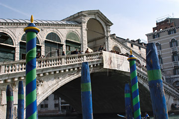 Comp image : ven021304 : The Rialto Bridge [Ponte di Rialto] over the Grand Canal [Canal Grande] in Venice, designed by Antonio da Ponte and completed in 1591; blue/green striped water markers in the foreground