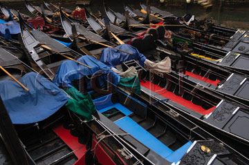 Comp image : ven021628 : Strong composition of closely packed black gondolas with red and blue boards moored on a canal in Venice, Italy