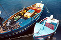 Looking down on two moored blue boats on a blue sea