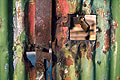 Close up of rusty metal on a peeling green painted corrugated iron gate Close up of rusty metal on a peeling green painted corrugated iron gate