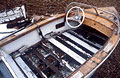 Old speedboat rotting on the shingle, showing seat and steering wheel