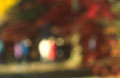 Very soft focus view of people among autumn colours and sunshine in an English wood