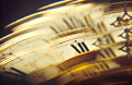 Blurry shattered image of part of an antique brass and white clock, showing 12 o'clock Blurry shattered image of part of an antique brass and white clock, showing 12 o'clock