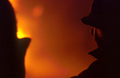 Silhouette of two heads watching a large bonfire Silhouette of two heads watching a large bonfire