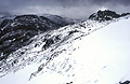 The High Stile ridge from Fleetwith Pike, in the English Lake District. Snow underfoot and a heavy sky above.