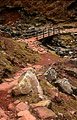 Footbridge below Scale Force waterfall, nr Crummock Water in the Lake District. Shows distinctive red rock.