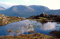 Summer sky reflected in a small tarn near Haystacks, over Buttermere in the English Lake District, with Great Gable and Green Gable in the hazy background