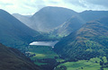 The distinctive square shape of Brothers Water from Place Fell, over Patterdale in the English Lake District, with Kirkstone Pass in hazy sun in the distance