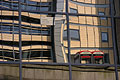 Distorted reflection in the glass of a London building, with two red telephone boxes