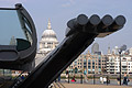 Dramatic end-on view of the Millennium Bridge over the River Thames in London, England, with St. Pauls Cathedral in sunshine on the other side of the river