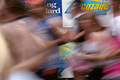 The blur of runners in the London Marathon, with parts of roadside advertisements in the background