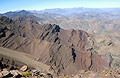 A view across sharp rocky peaks in the vast landscape of the High Atlas mountains of Morocco, from the side of Jebel Rhat, in strong sunshine