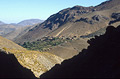 View across a high valley in morning sunshine in the High Atlas mountains of Morocco, with heavy shadows of the mountainside in the foreground