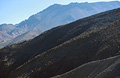 Heavily shadowed hillside in the foreground and distant hazy mountains, in the High Atlas mountain range in Morocco