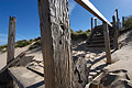 Part of an old wooden structure on the sand dunes on the North Norfolk coast of England, under a blue sky