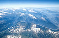 Blue aerial view of the Swiss Alps, with patches of snow