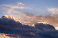 A heavy band of ominous pink tinted dark cloud in a blue sky