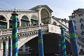 The Rialto Bridge [Ponte di Rialto] over the Grand Canal [Canal Grande] in Venice, designed by Antonio da Ponte and completed in 1591; blue/green striped water markers in the foreground