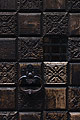 Close-up of part of an old carved wooden door with a cast iron handle in Venice, Italy
